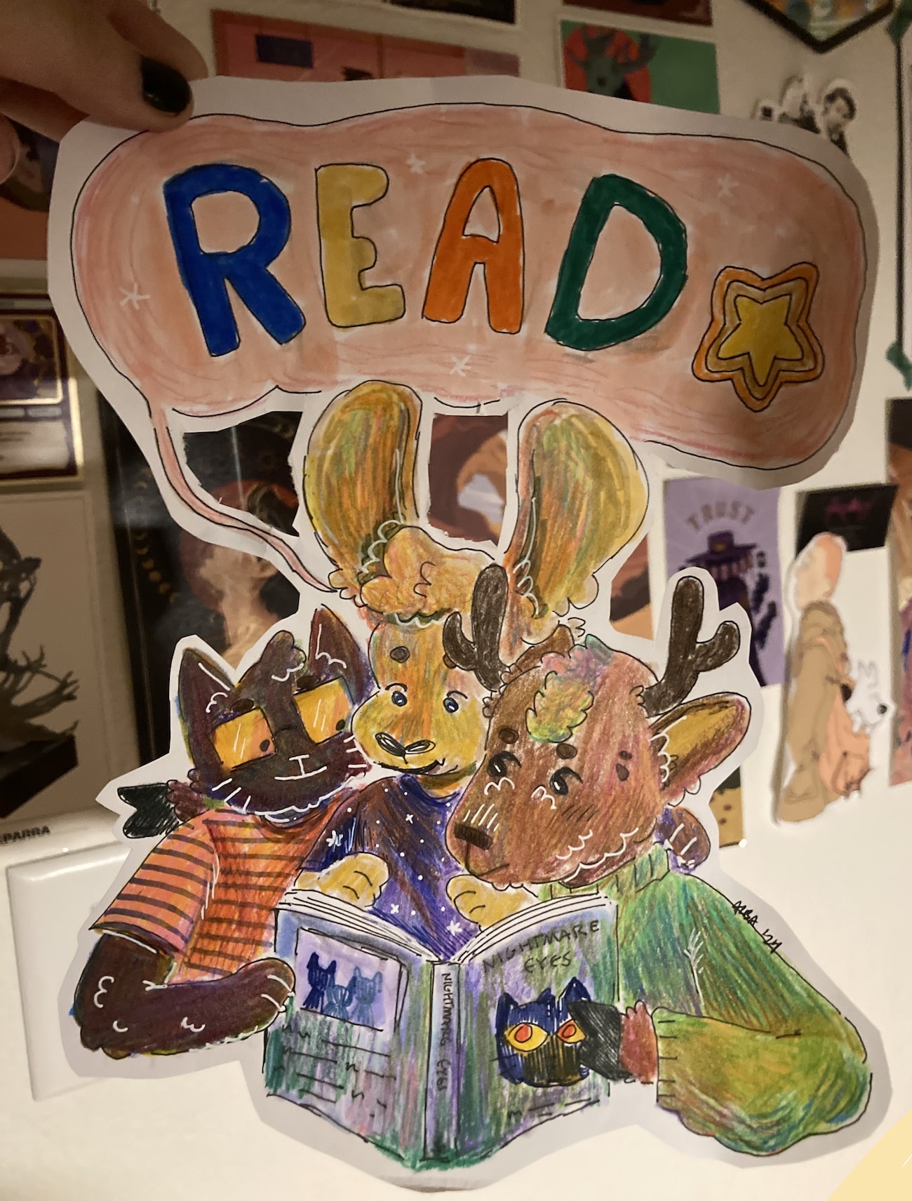 A drawing in colored pencil, ink, and marker of a cat, rabbit, and deer reading together.