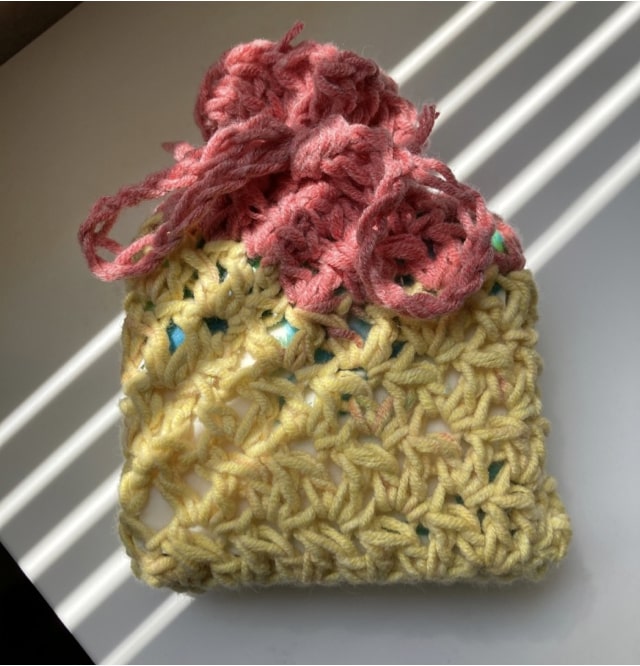 A bar of soap inside a crocheted bag.